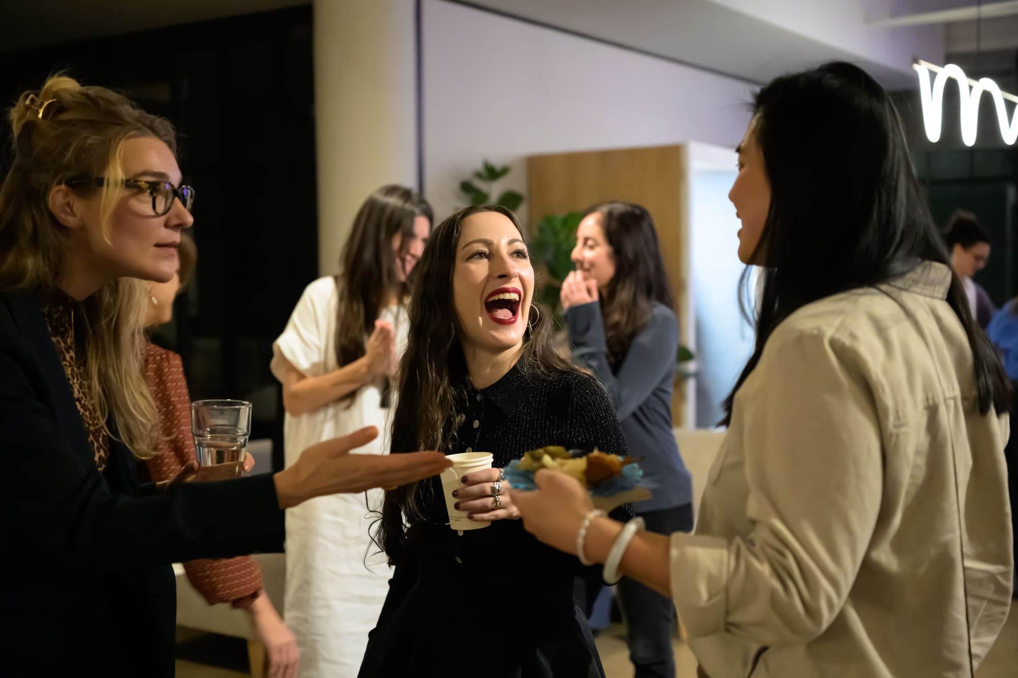 Women laughing and socializing at Revery Root & Ritual event