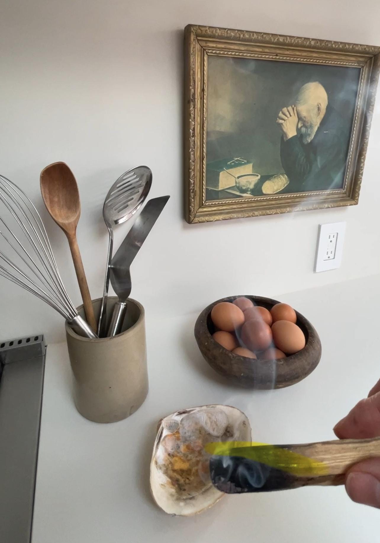 A single piece of palo santo wood is burning, releasing a swirl of sweet-smelling smoke