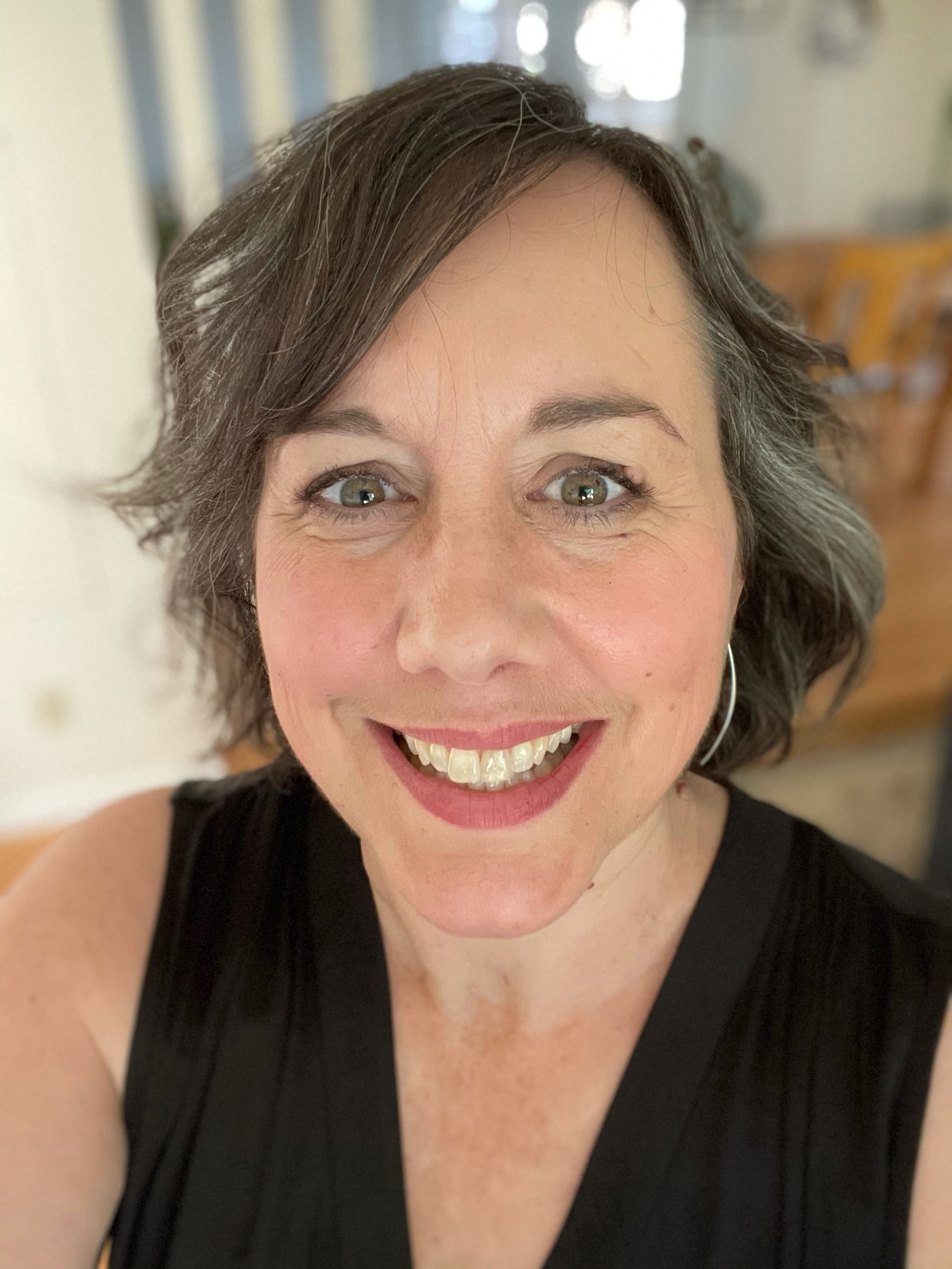 Close up of woman with short, wavy gray hair and bright smile