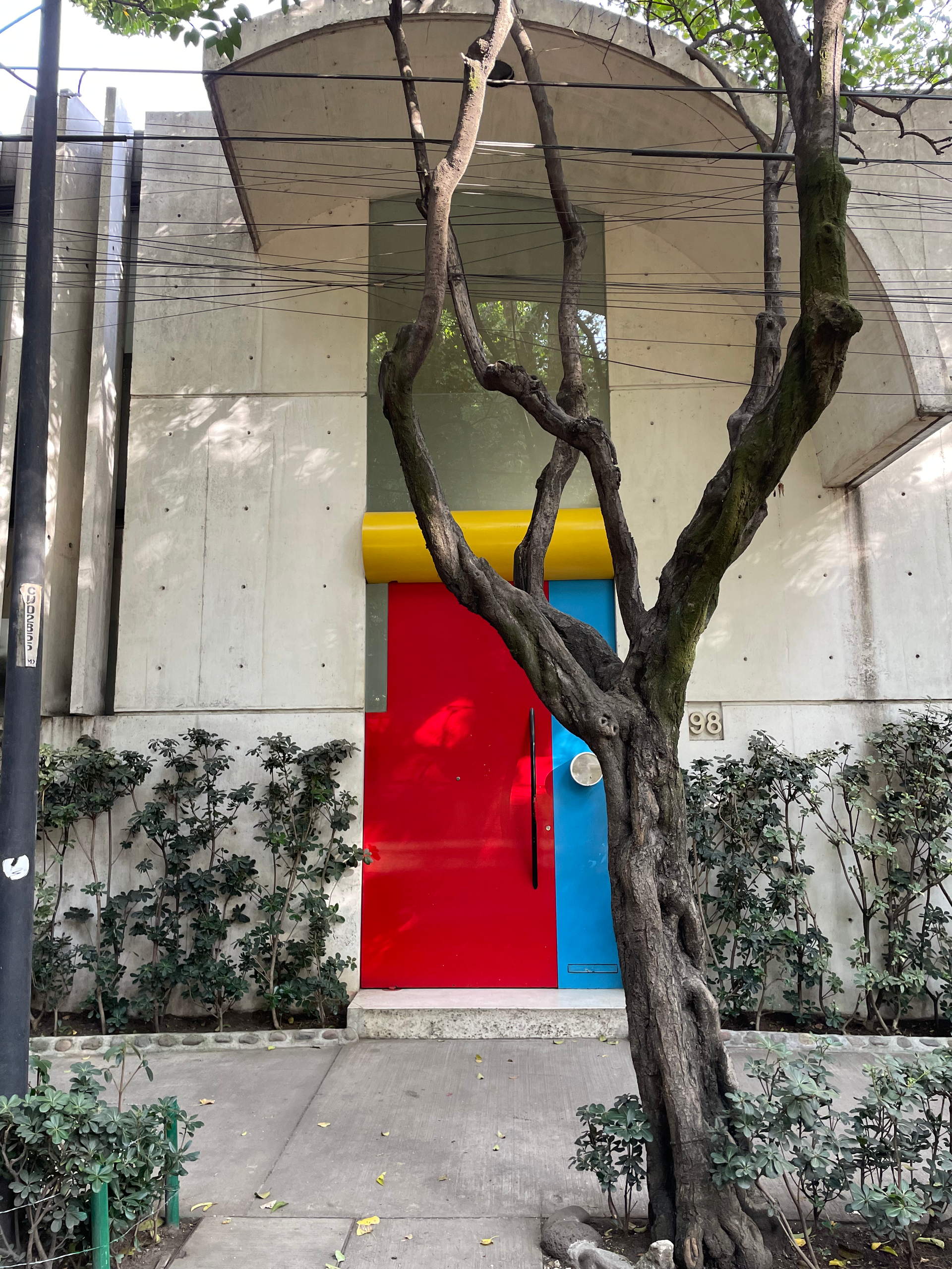 Red, yellow, and blue door on a vine-covered Art Deco house